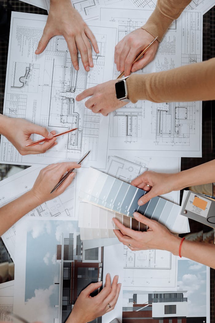 Team working together on architectural blueprints and color swatches.